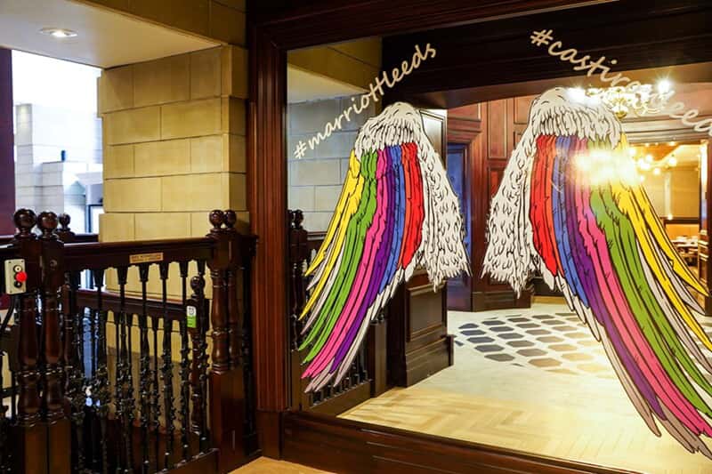 An image of window signage showing colorful angel wings.